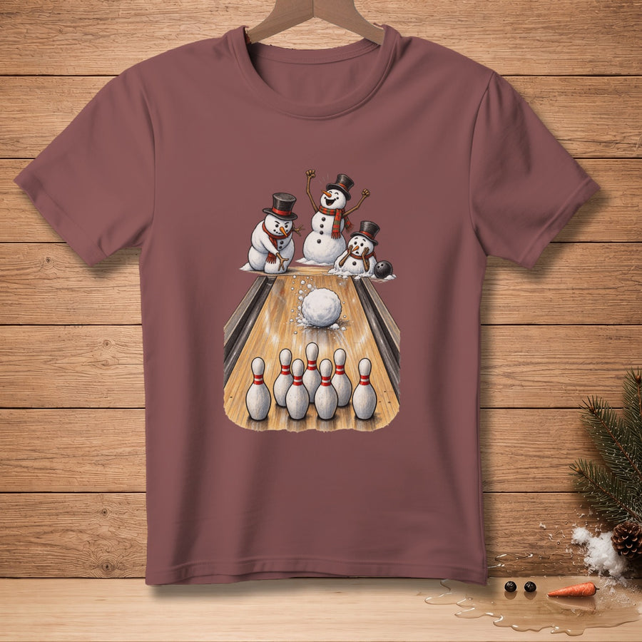 Three snowmen in hats play bowling on a wooden lane with pins and a ball.