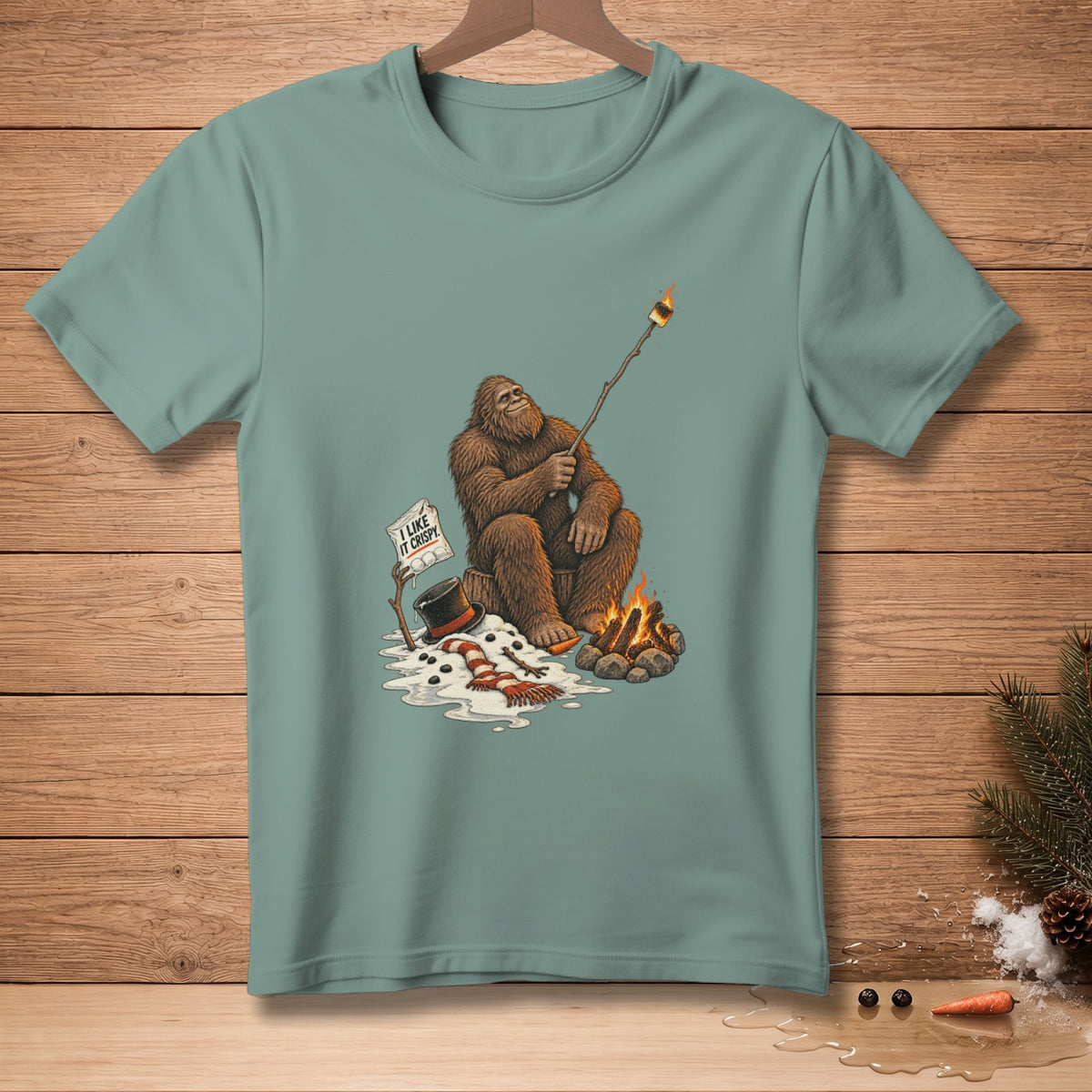 Bigfoot toasting a marshmallow over a campfire with a "I like it crispy" sign.
