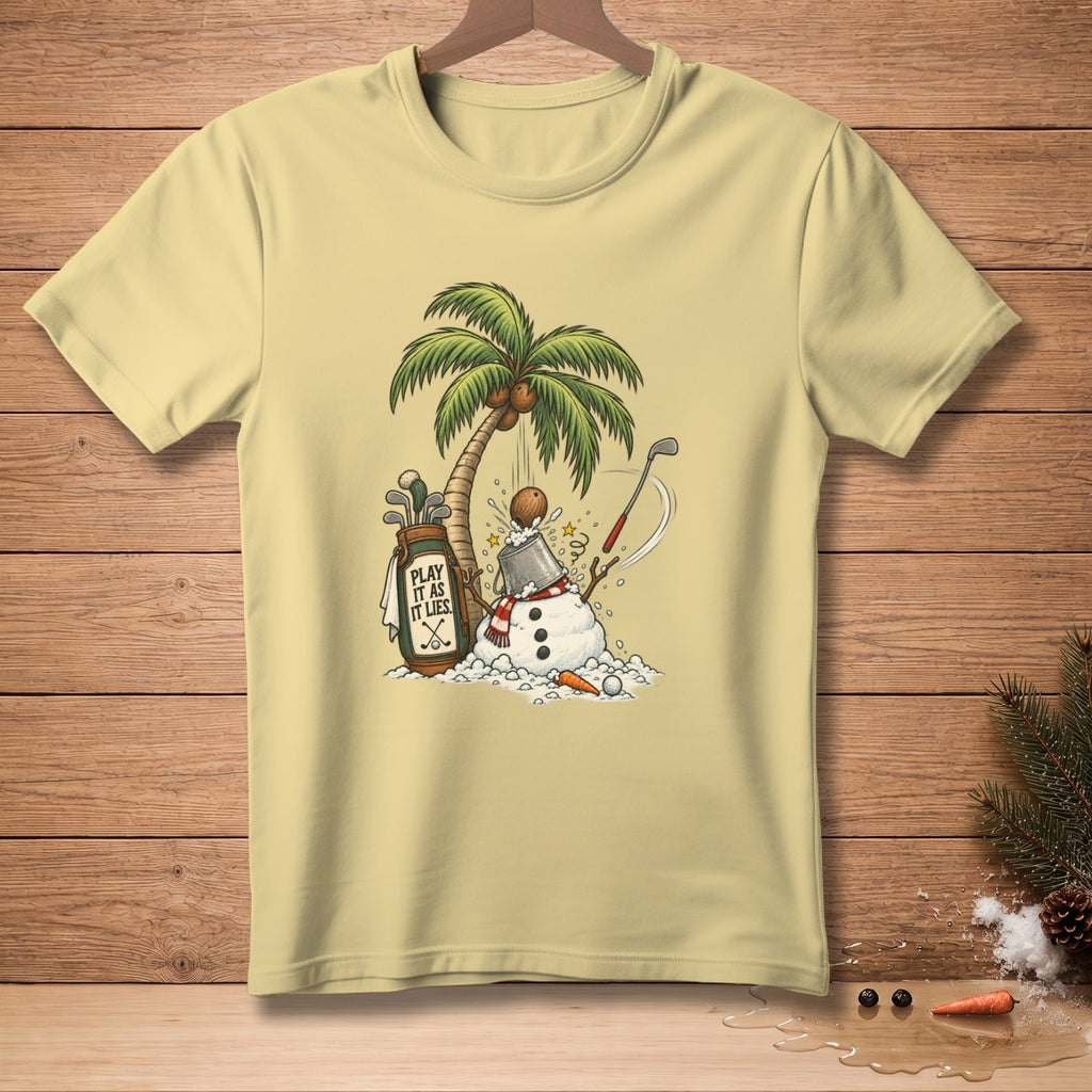 Light yellow t-shirt with snowman, palm tree, golf bag, and "Play It As It Lies" text.