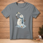 Melting snowman with a scarf drying itself with a hairdryer on a grey t-shirt.