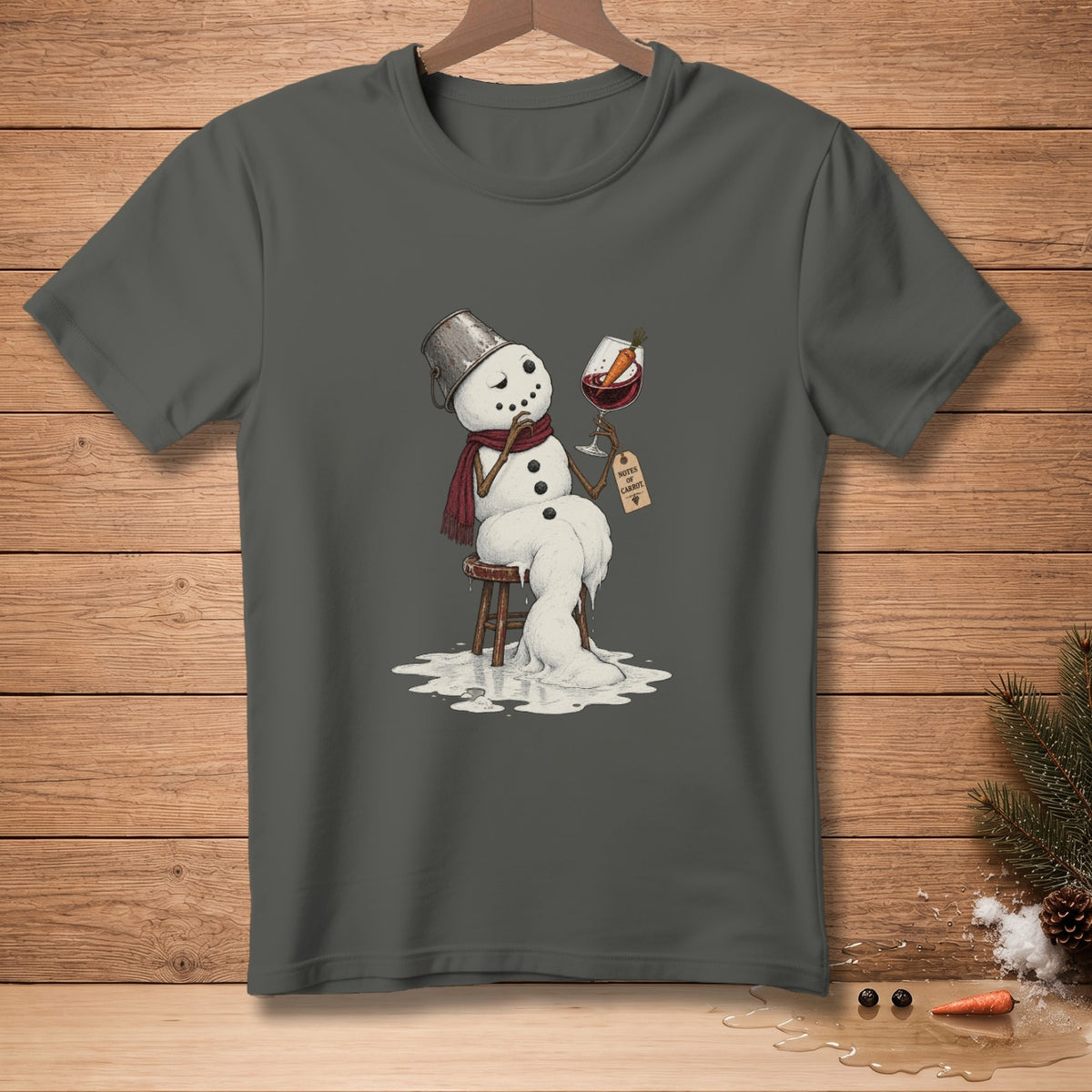 Melting snowman with wine glass labeled "Notes of Carrot" on dark grey t-shirt.