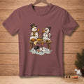 Two snowmen on a table, one cooking corn dogs while the other melts.