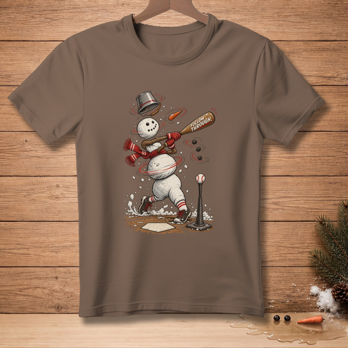 Brown t-shirt with graphic of snowman playing baseball, reading "Follow Through."