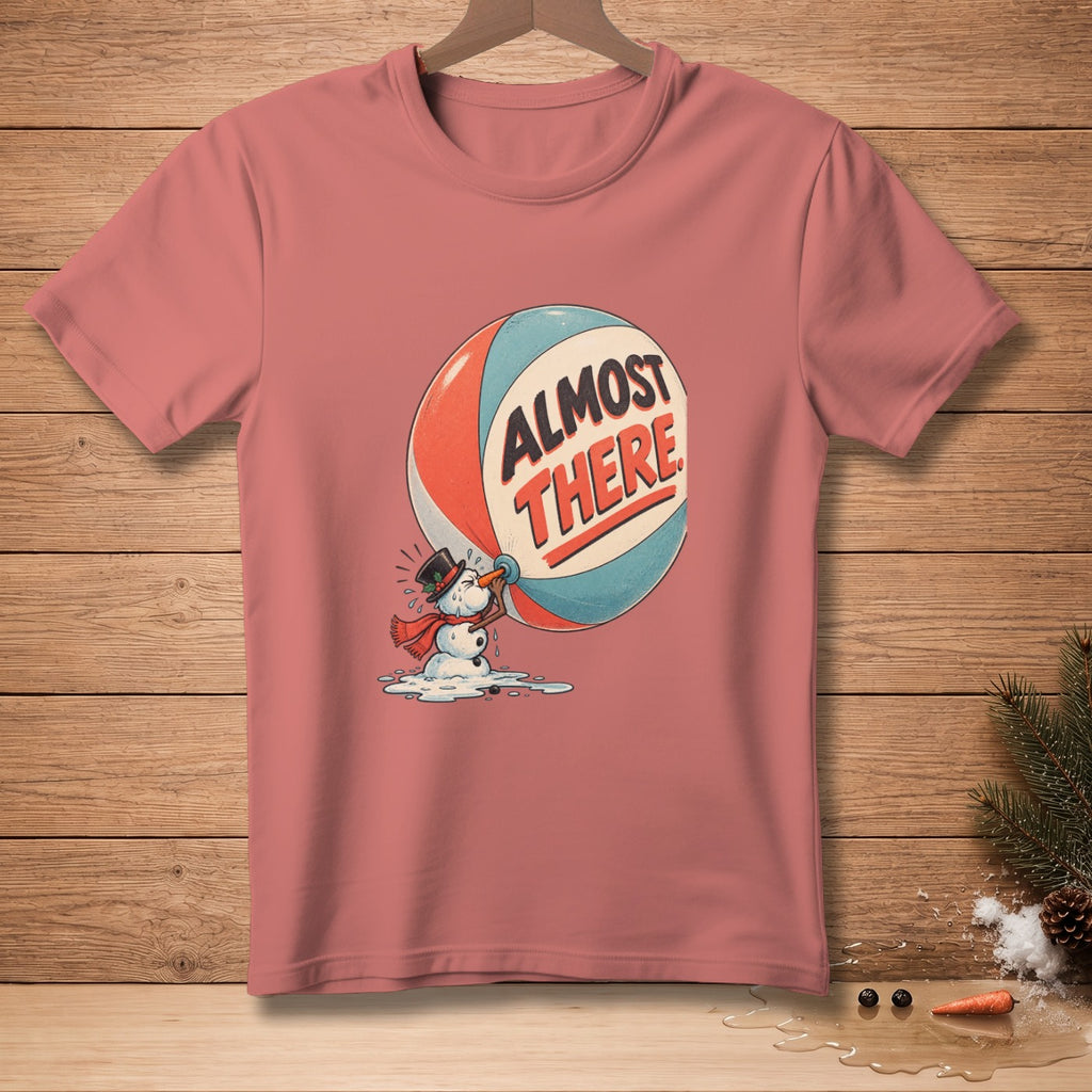 Pink t-shirt with melting snowman holding a beach ball that reads "Almost There".