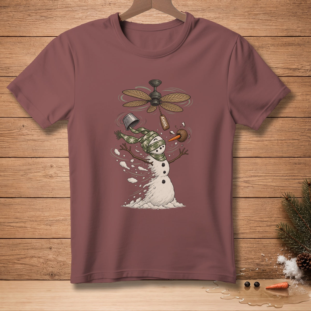 Snowman with spinning fan, bucket, and carrot on maroon t-shirt.