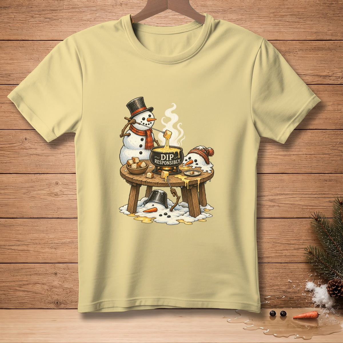 Snowmen enjoying fondue with text "DIP RESPONSIBLY" on a light yellow t-shirt.