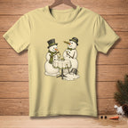 Two snowmen in hats and scarves toast with martinis at a table.