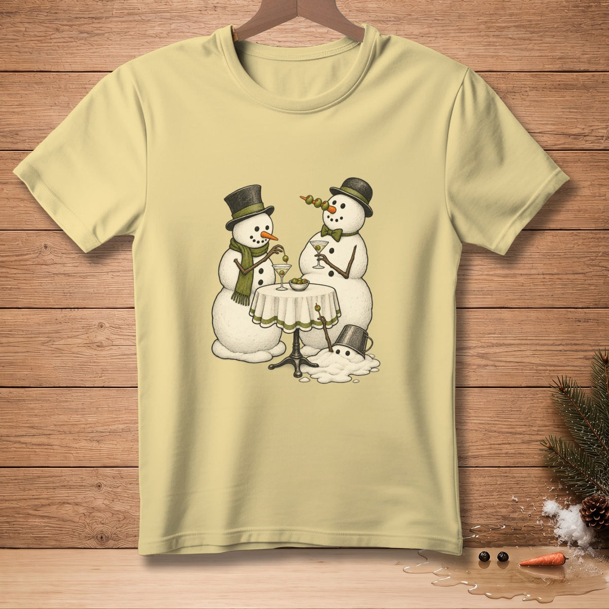 Two snowmen in hats and scarves toast with martinis at a table.