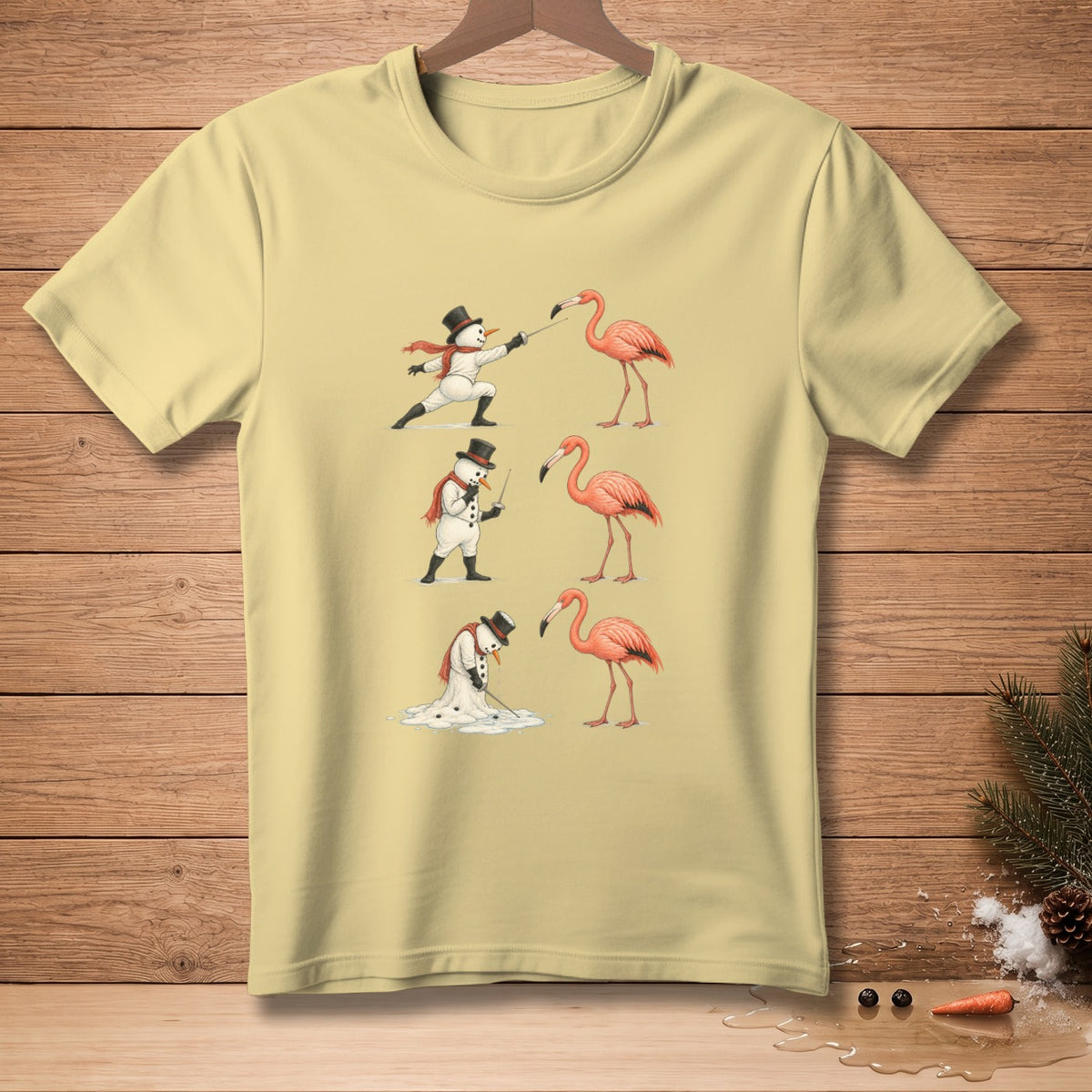Light yellow t-shirt with cartoon snowmen interacting with flamingos.