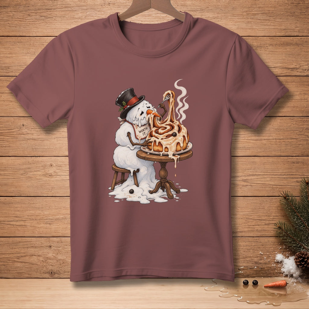 Melting snowman in a hat eats a giant cinnamon roll from a table.