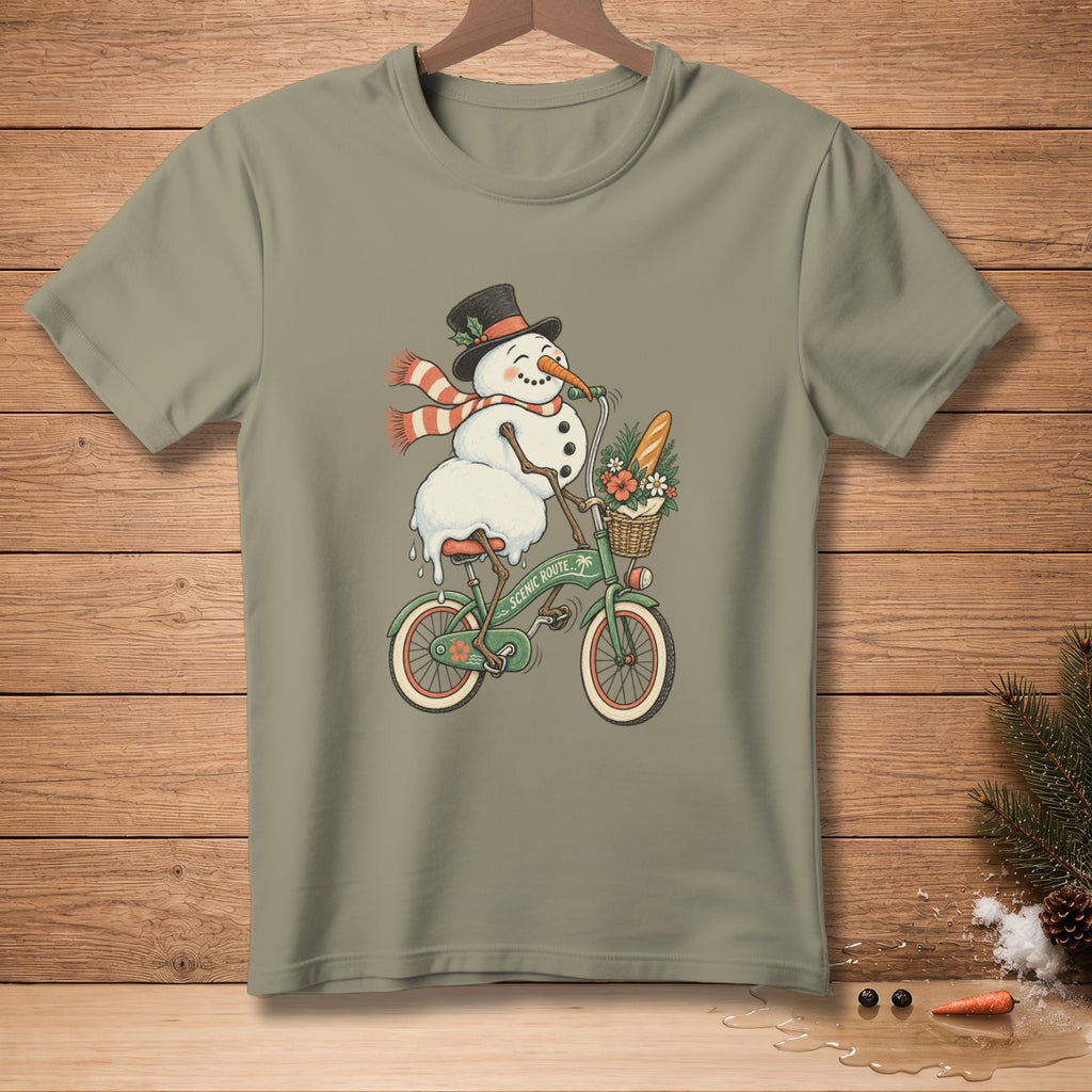 Snowman riding a green bicycle with a basket of flowers and baguette.