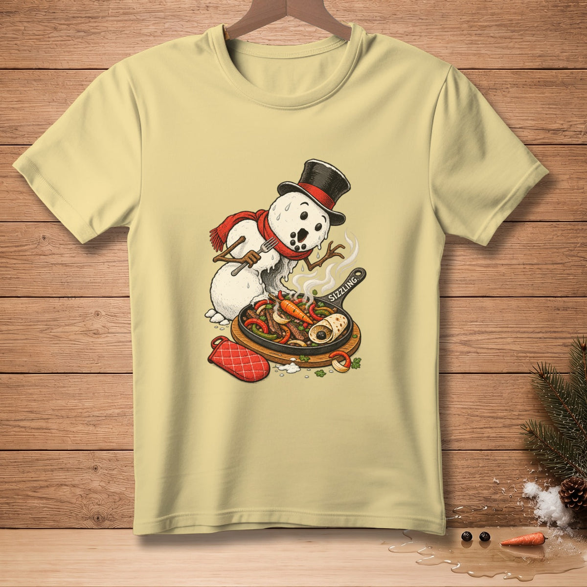 Snowman in a hat and scarf cooking sizzling fajitas with a fork on a light yellow t-shirt.