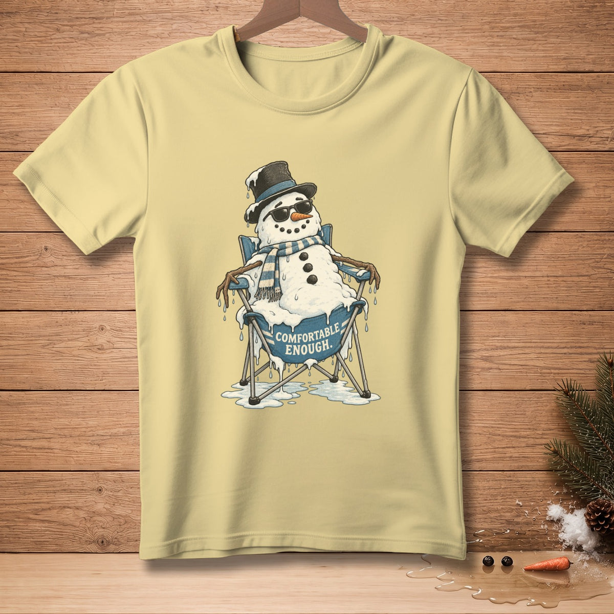 Yellow t-shirt with melting snowman in a chair, text "COMFORTABLE ENOUGH."