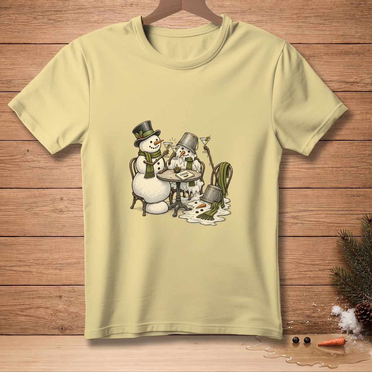 Two melting snowmen with drinks and a "Cheers" sign on a light yellow t-shirt.