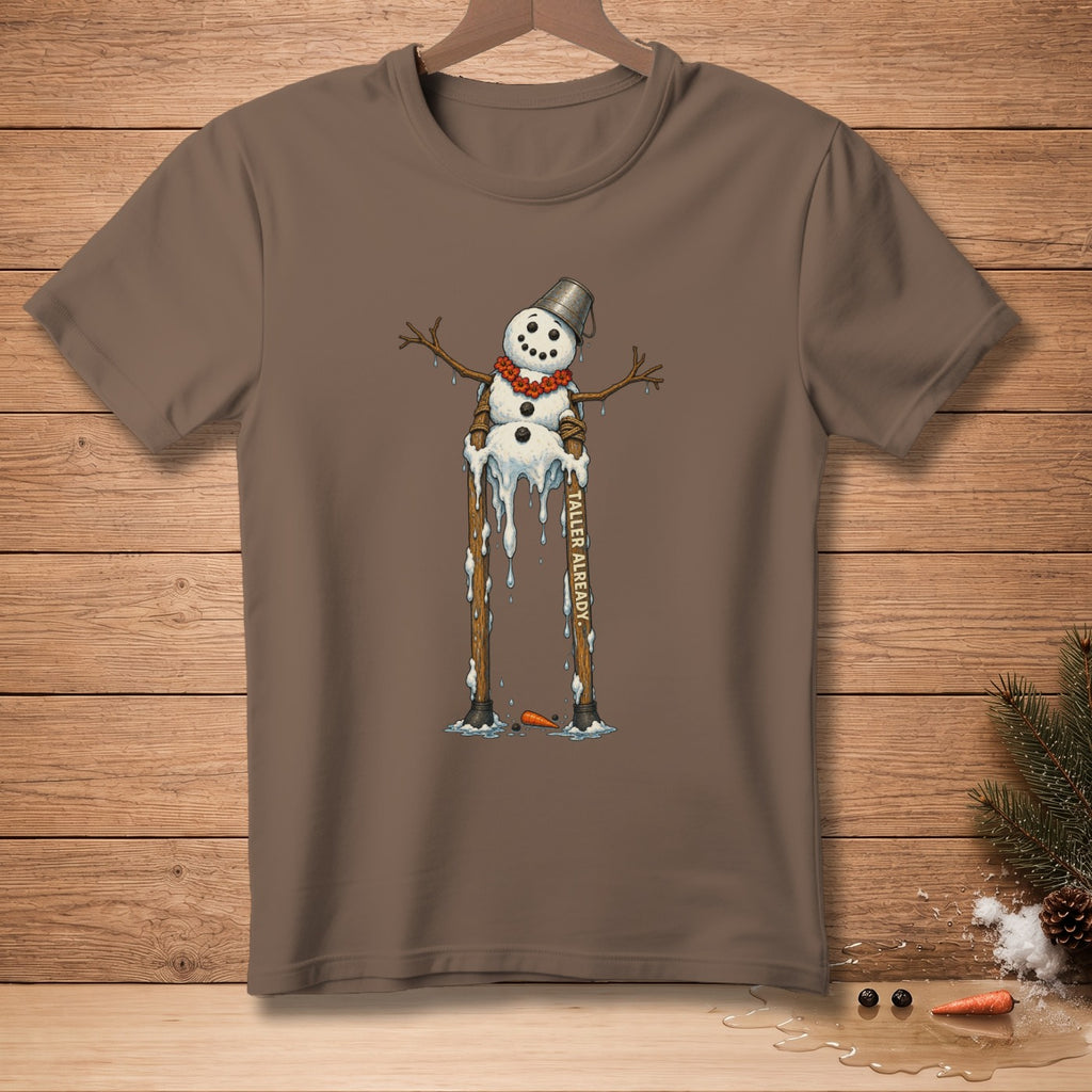 Brown t-shirt with a melting snowman on stilts, text reads "TALLER ALREADY."
