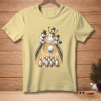 Snowmen bowling on a light yellow t-shirt with a wooden background.