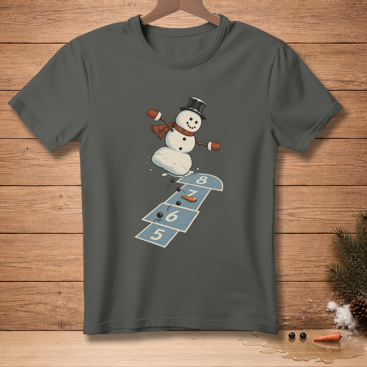 Snowman wearing a top hat and scarf playing hopscotch on a gray t-shirt.