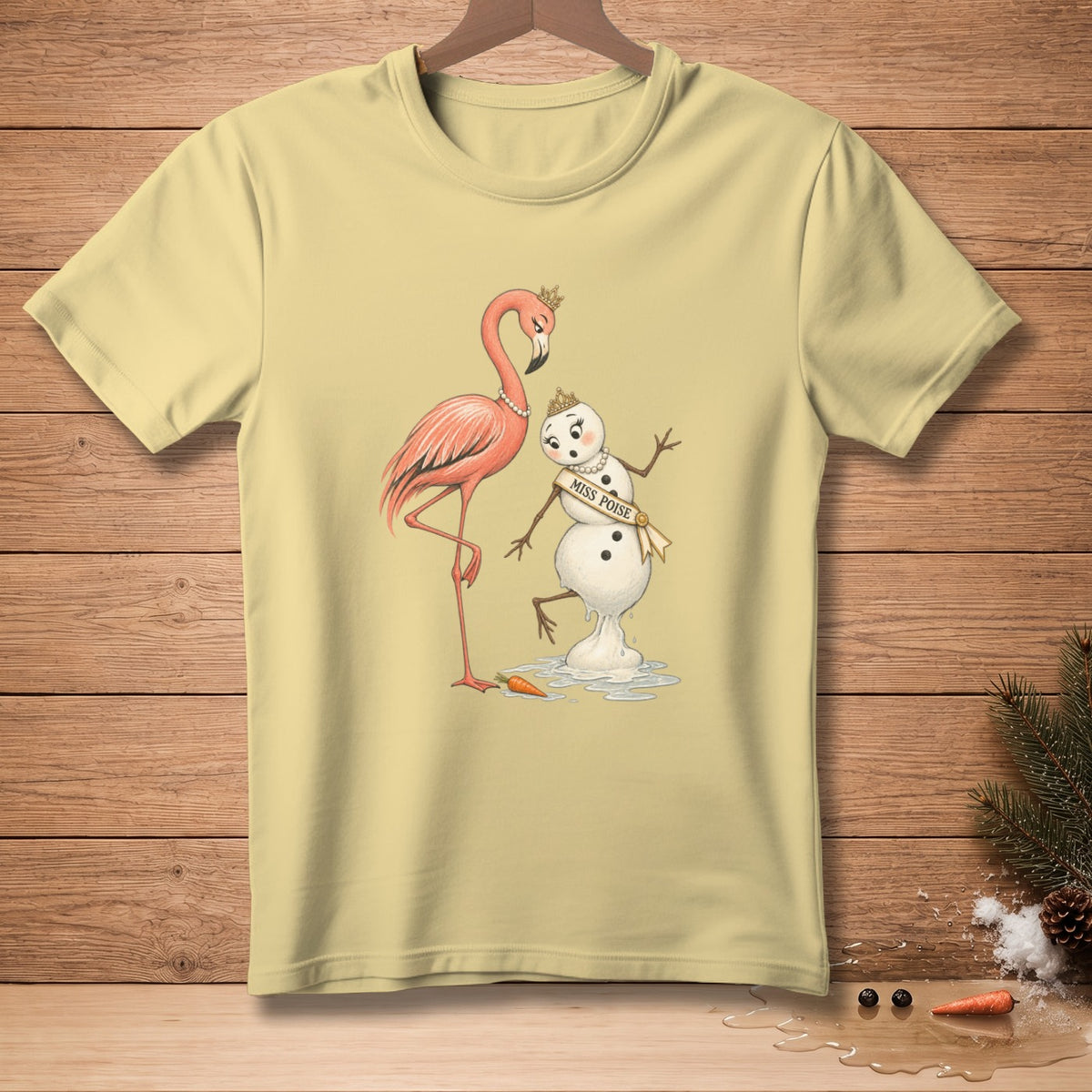 Light yellow t-shirt with a flamingo and melting snowman wearing a "Miss Poise" sash.