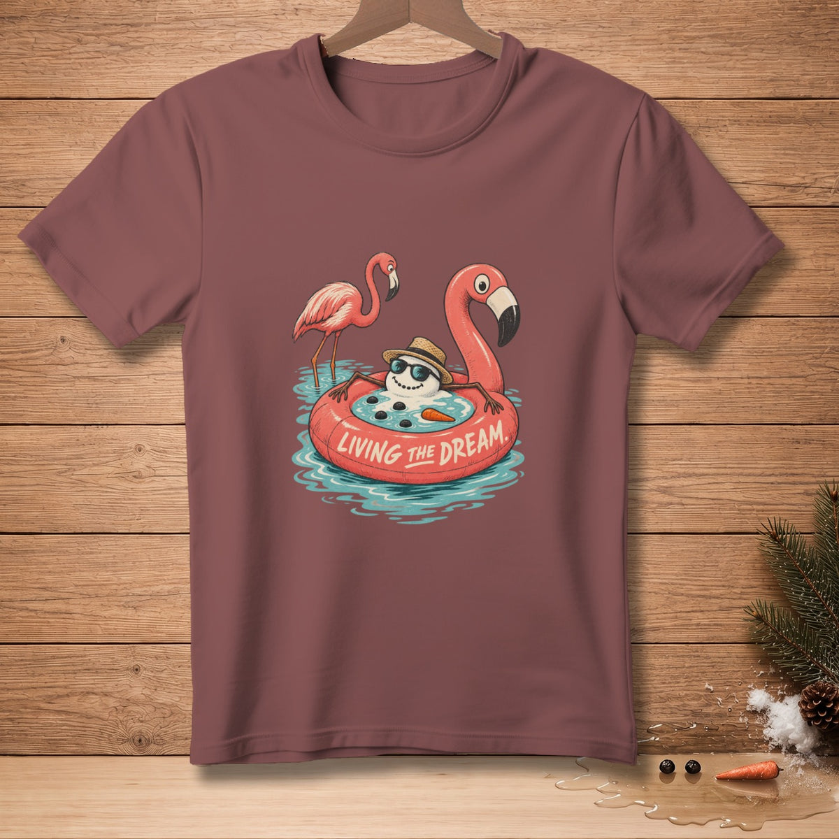 T-shirt with cartoon snowman on flamingo float, text "LIVING THE DREAM".