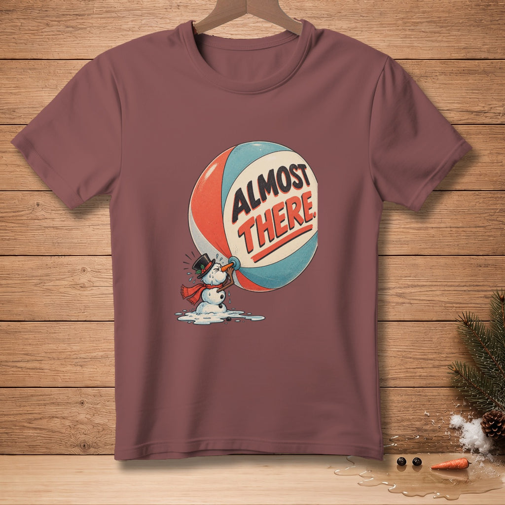T-shirt with melting snowman pushing a large ball that says "ALMOST THERE".