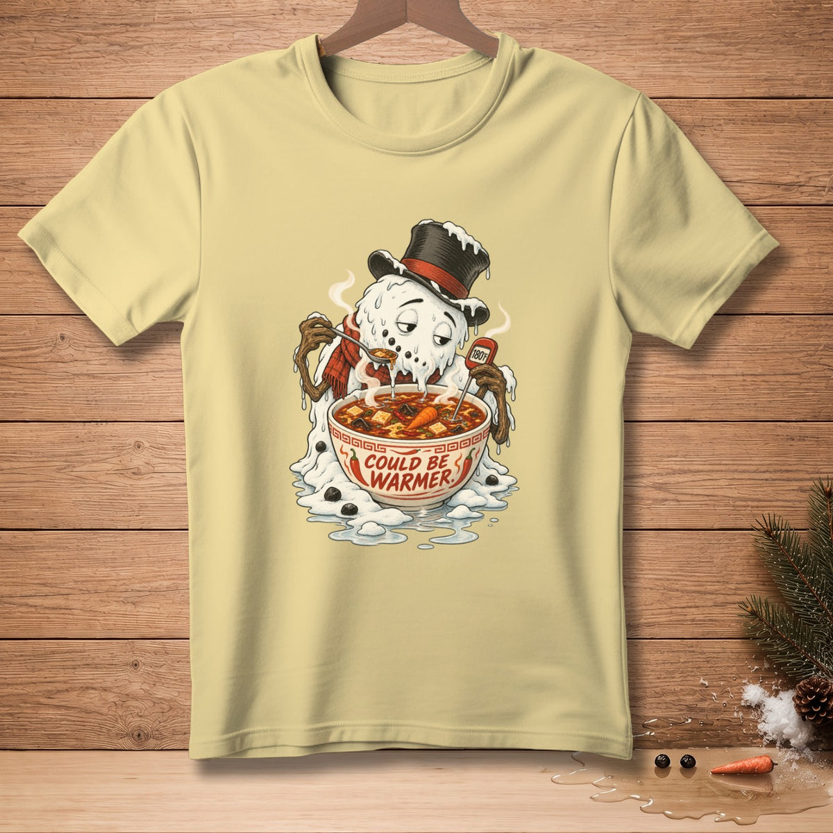 Melting snowman in a hat eats soup from a bowl that says "COULD BE WARMER".