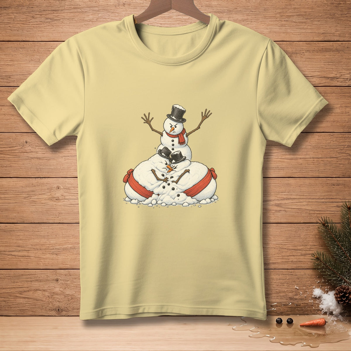 Light yellow t-shirt with cartoon snowmen piled on top of each other wearing hats and scarves.