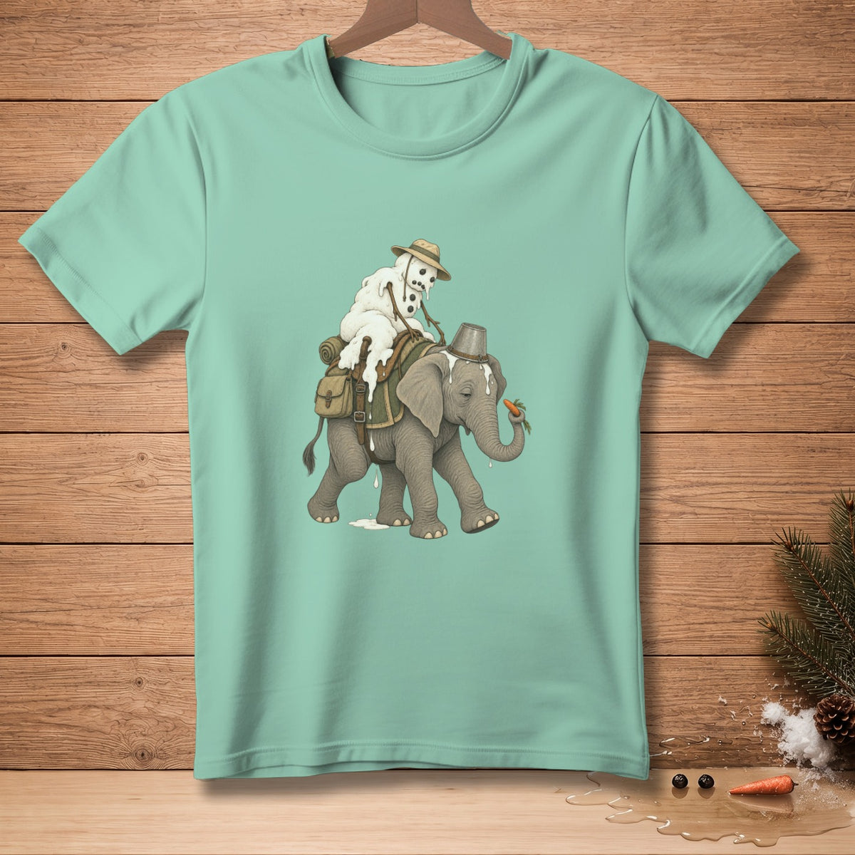 Snowman riding a melting elephant with a bucket and carrot on teal t-shirt.