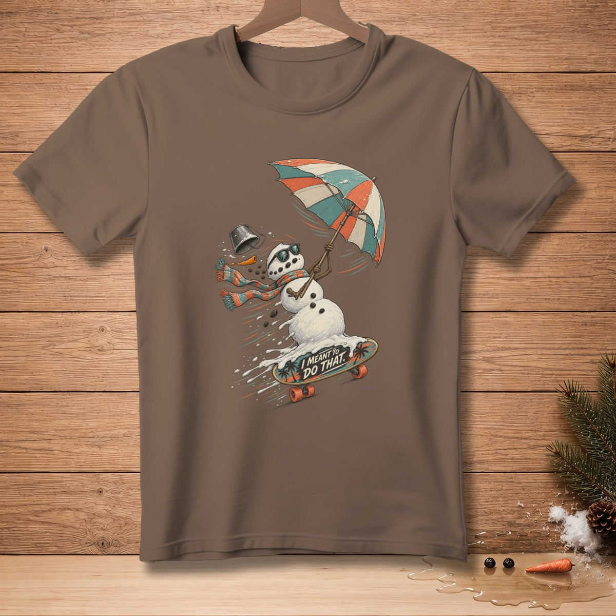Snowman skateboarding under a colorful umbrella, text reads "I MEANT TO DO THAT."