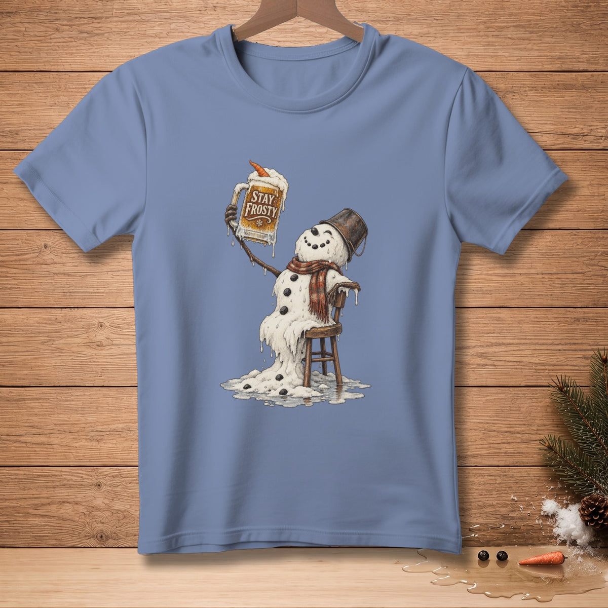 Melting snowman sitting on chair holding a mug that says "Stay Frosty".