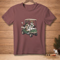 Two snowmen in sunglasses and scarves ride a golf cart with clubs and a "Hole 2" sign.
