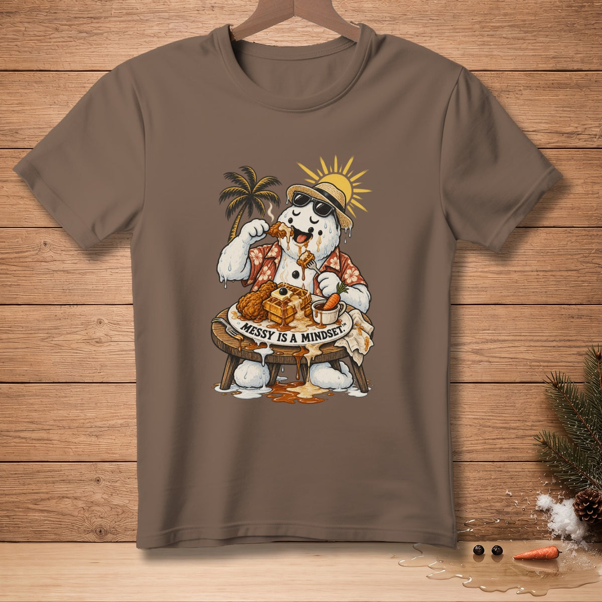 Snowman wearing sunglasses and a Hawaiian shirt eats fried chicken and waffles, text reads "Messy is a mindset."