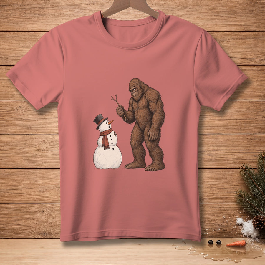 Bigfoot holding a stick looks at a snowman wearing a top hat and scarf.