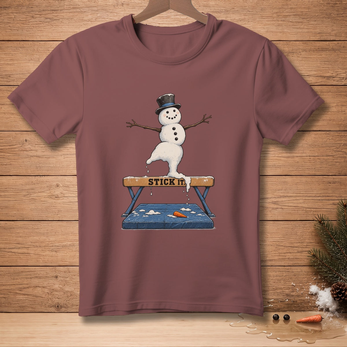 Snowman in a top hat balances on a gymnastics beam with text "STICK IT".