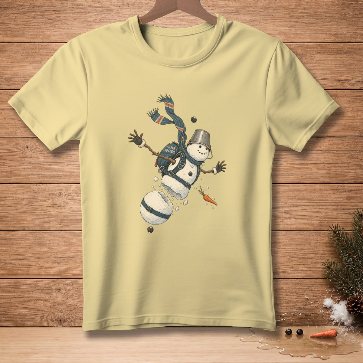 Light yellow t-shirt with a graphic of a snowman falling apart.