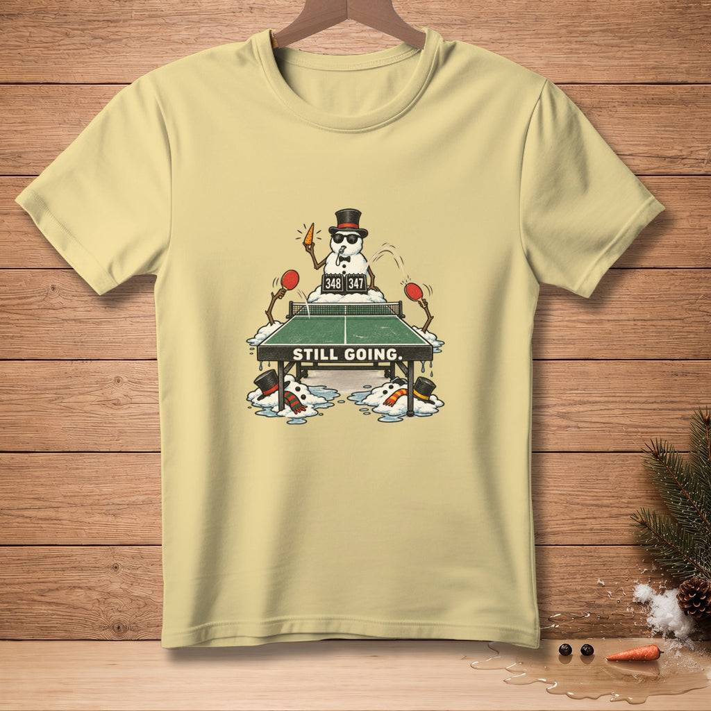 T-shirt with snowmen playing ping pong and "STILL GOING." text.