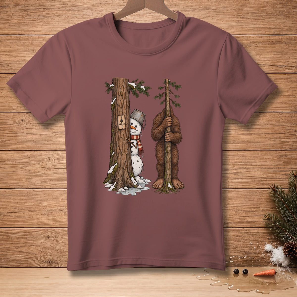 Snowman peeking from behind tree with "Nailed It" sign next to Bigfoot holding a small tree.