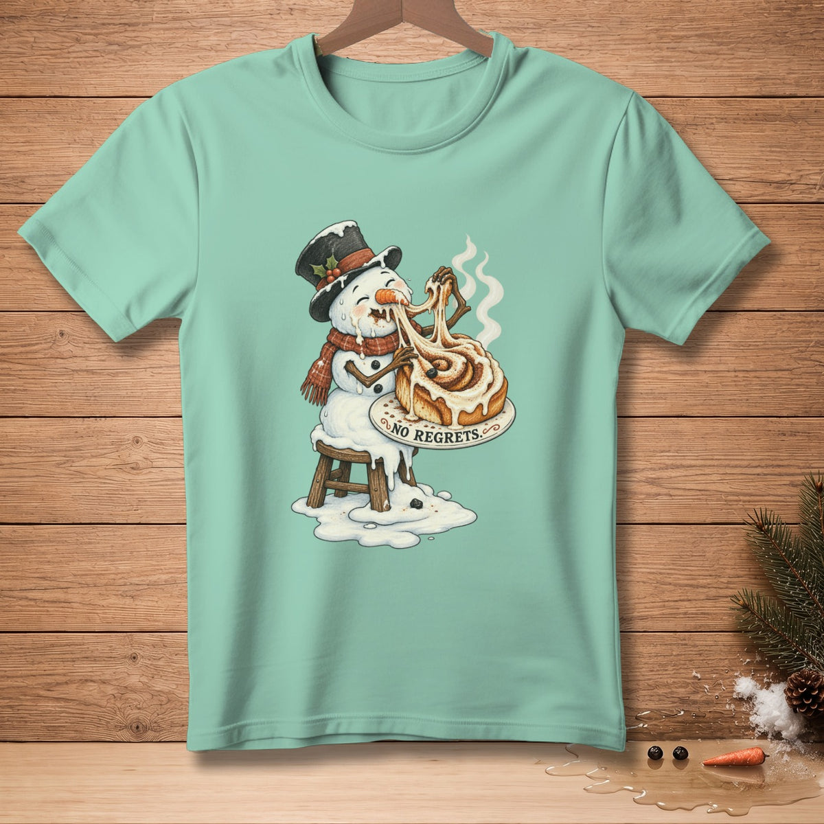 Snowman wearing hat and scarf, melting while eating a cinnamon roll, text "NO REGRETS".