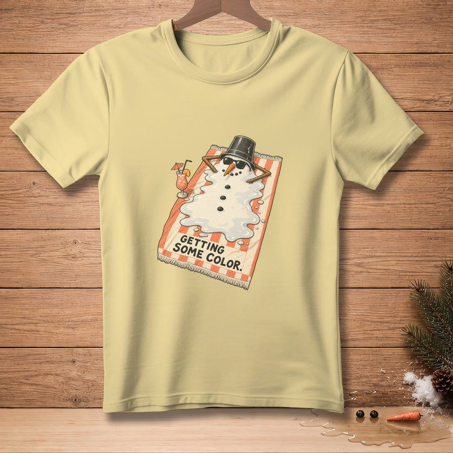 T-shirt graphic: Melting snowman wearing sunglasses, lying on a beach towel, with text "GETTING SOME COLOR."