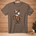Brown t-shirt featuring a bull riding a bucking machine, with a snowman holding a carrot.