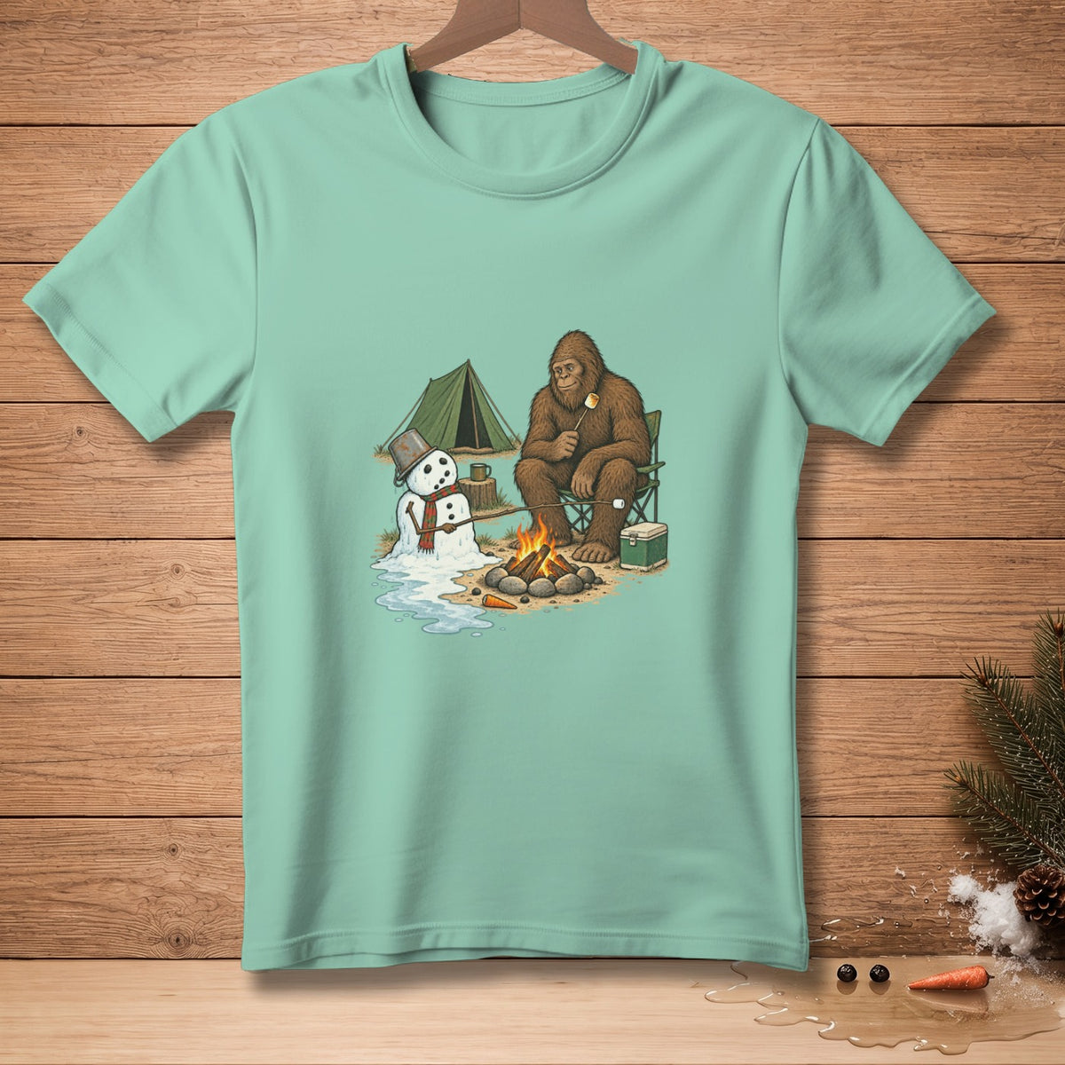Bigfoot sits by a campfire, toasting a marshmallow, near a melting snowman and tent.