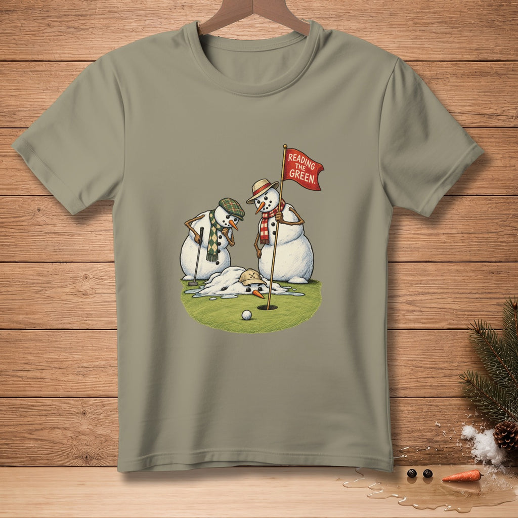 Two snowmen golf, one melting near a hole with a flag reading "Reading The Green."