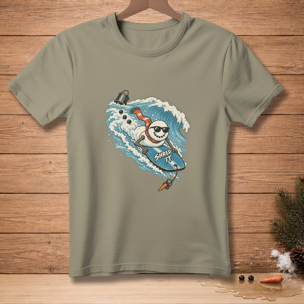 Snowman surfing a wave on a surfboard with "Shred It" text.