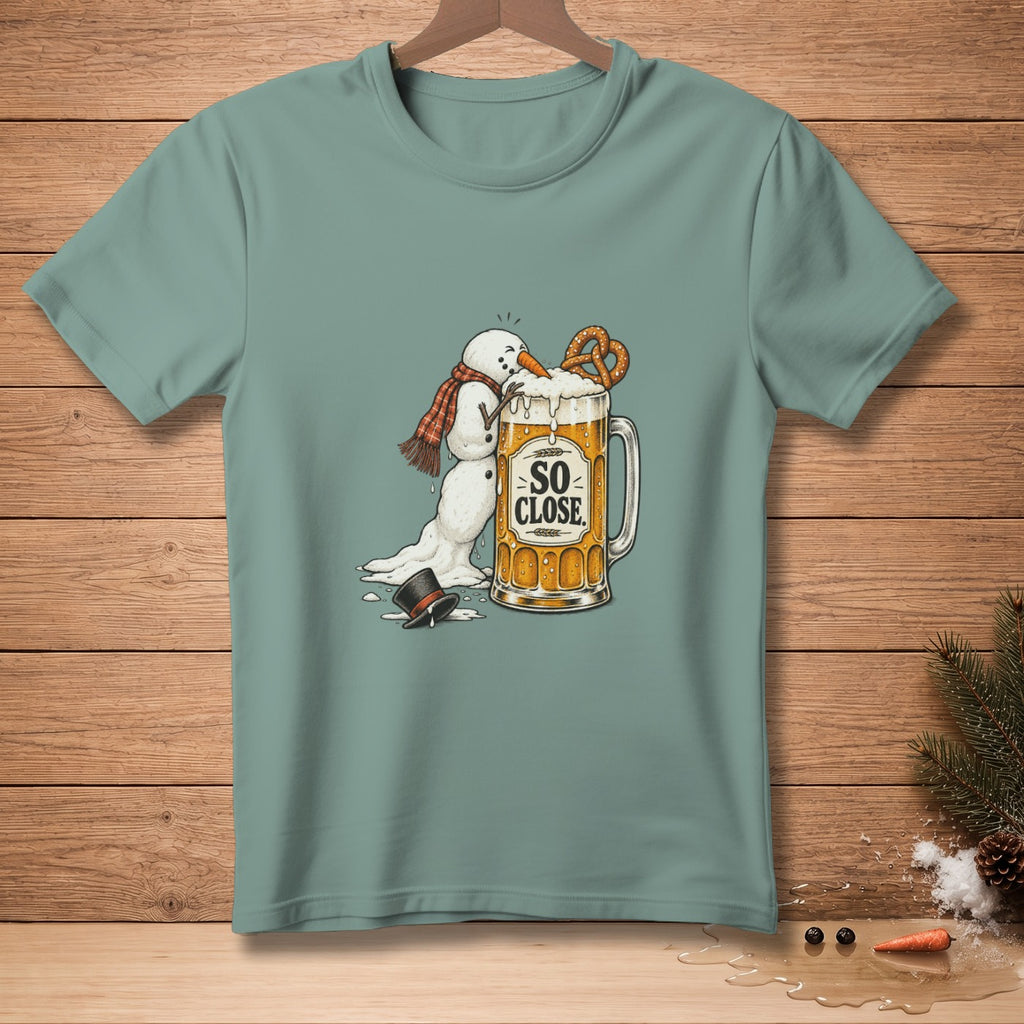 Melting snowman reaching for pretzel in beer mug with "SO CLOSE" text.
