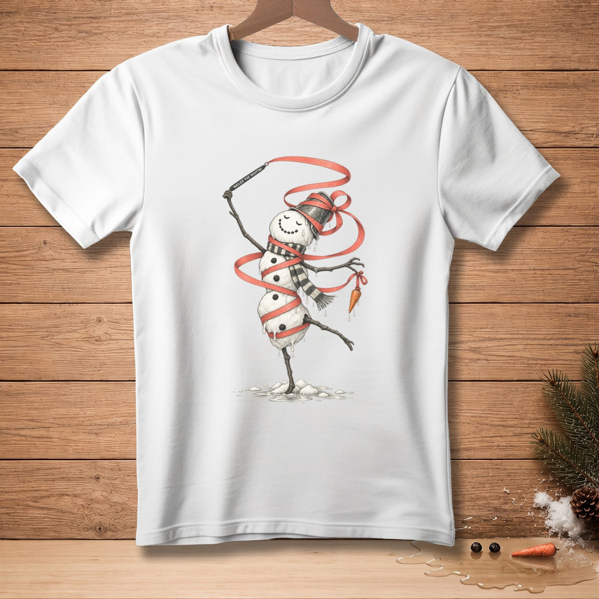 White t-shirt featuring a snowman dancing with a red ribbon and holding a carrot.
