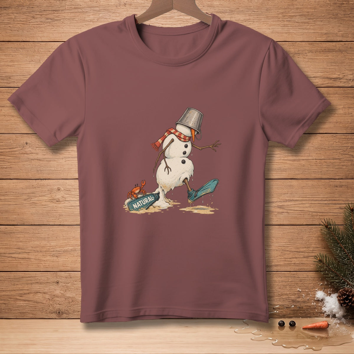 Melting snowman with crab, bucket, scarf, and "NATURAL" sign on t-shirt.