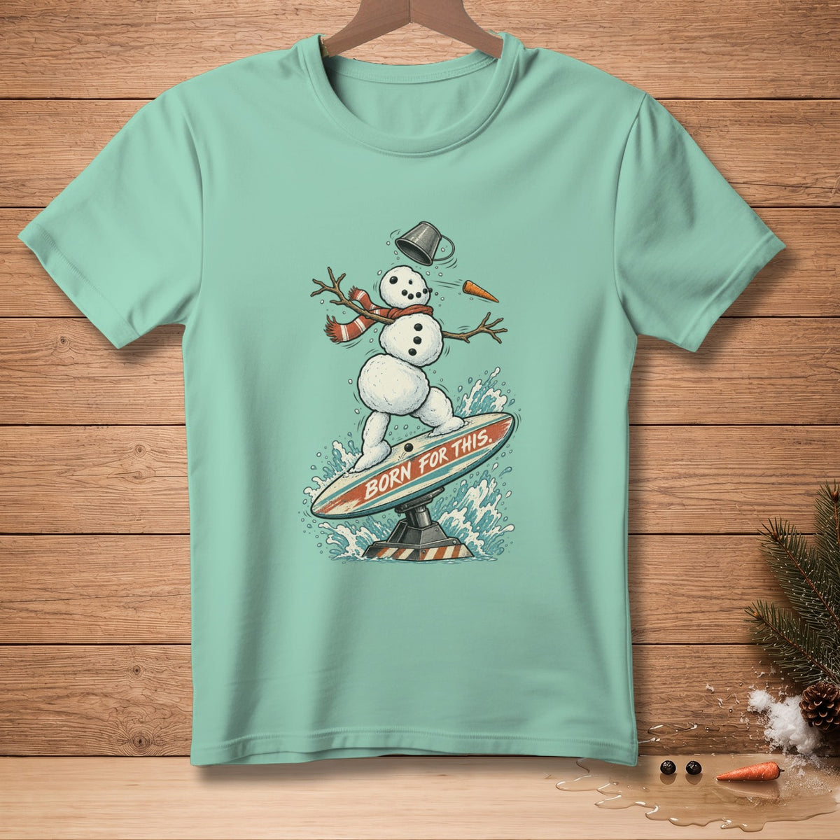 Snowman surfing on a board with text "BORN FOR THIS" and splash of water.