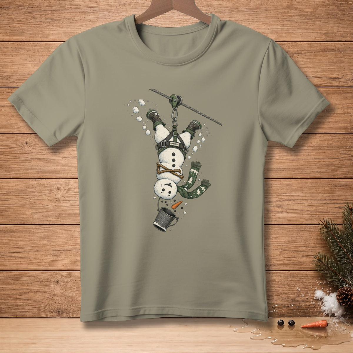 Snowman on zip line wearing harness, holding bucket, with text "PLANNED IT".