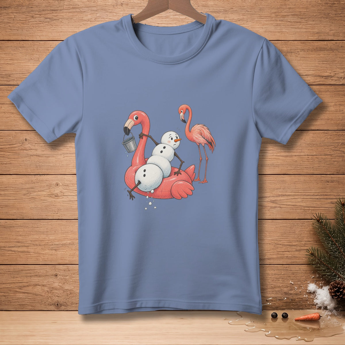 T-shirt graphic of a snowman on a pink flamingo float with another flamingo.