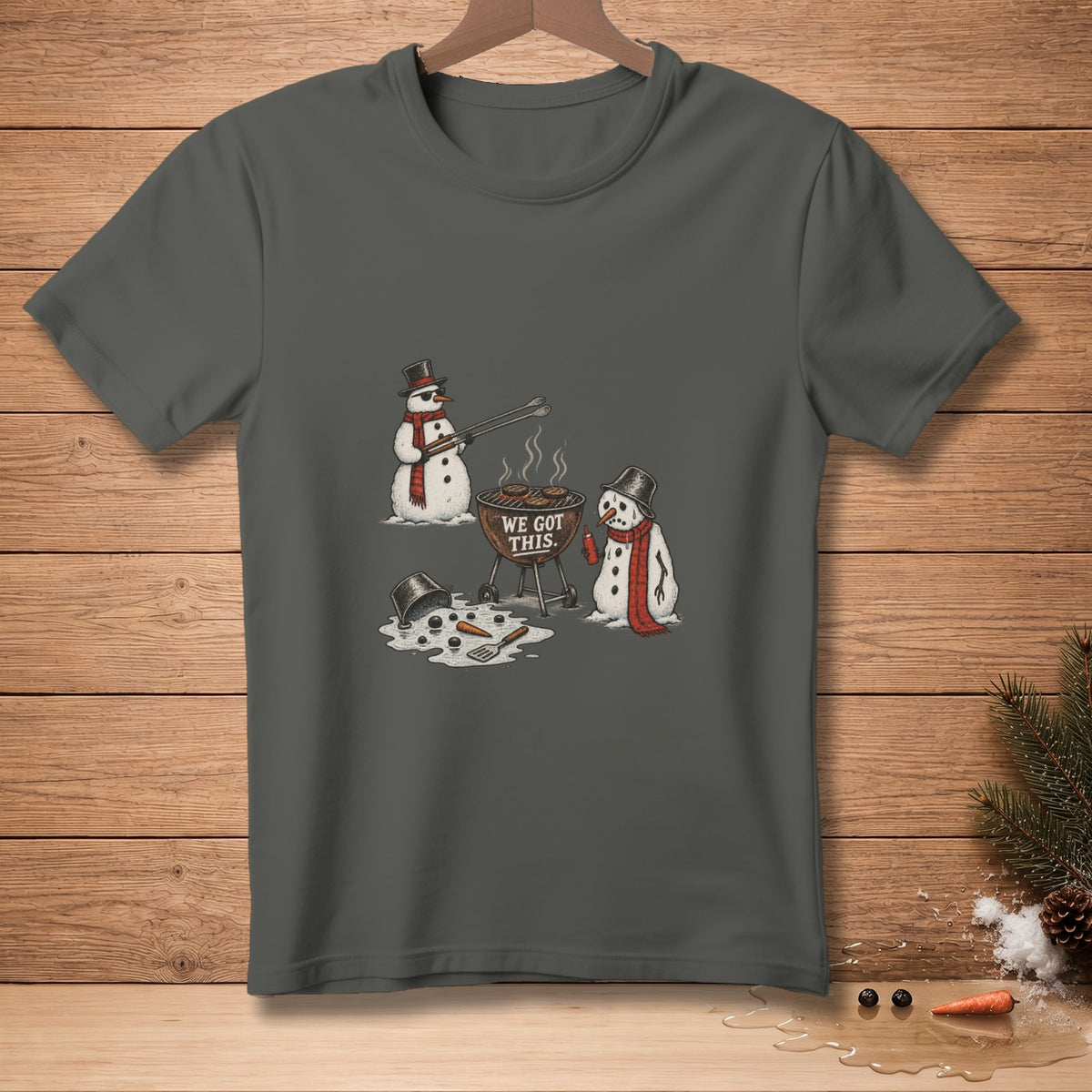 Two snowmen are grilling, one holding tongs over burgers. "WE GOT THIS." text on grill.