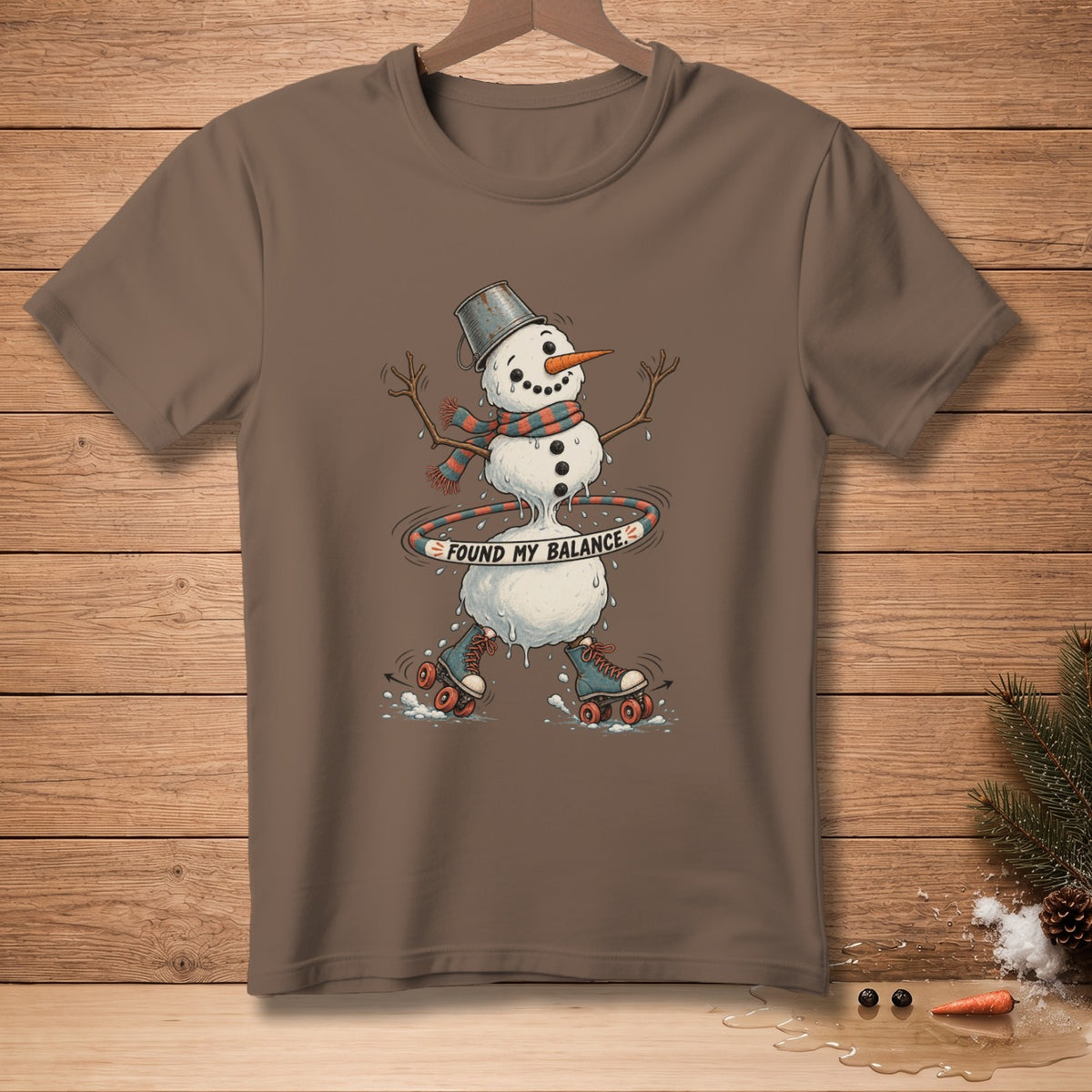 Brown t-shirt with melting snowman on roller skates and text "Found My Balance".